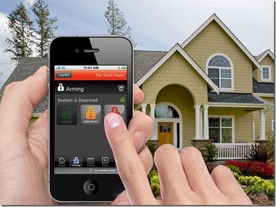 A person is holding a smart phone in front of a house