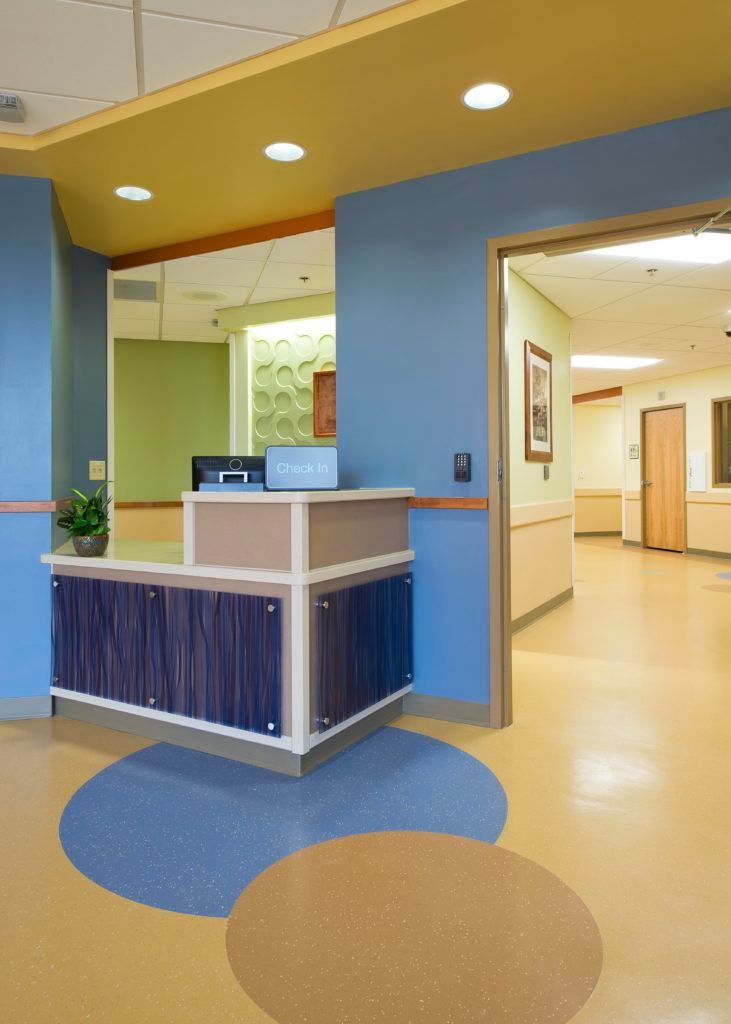 A reception desk in a hospital with blue and yellow walls