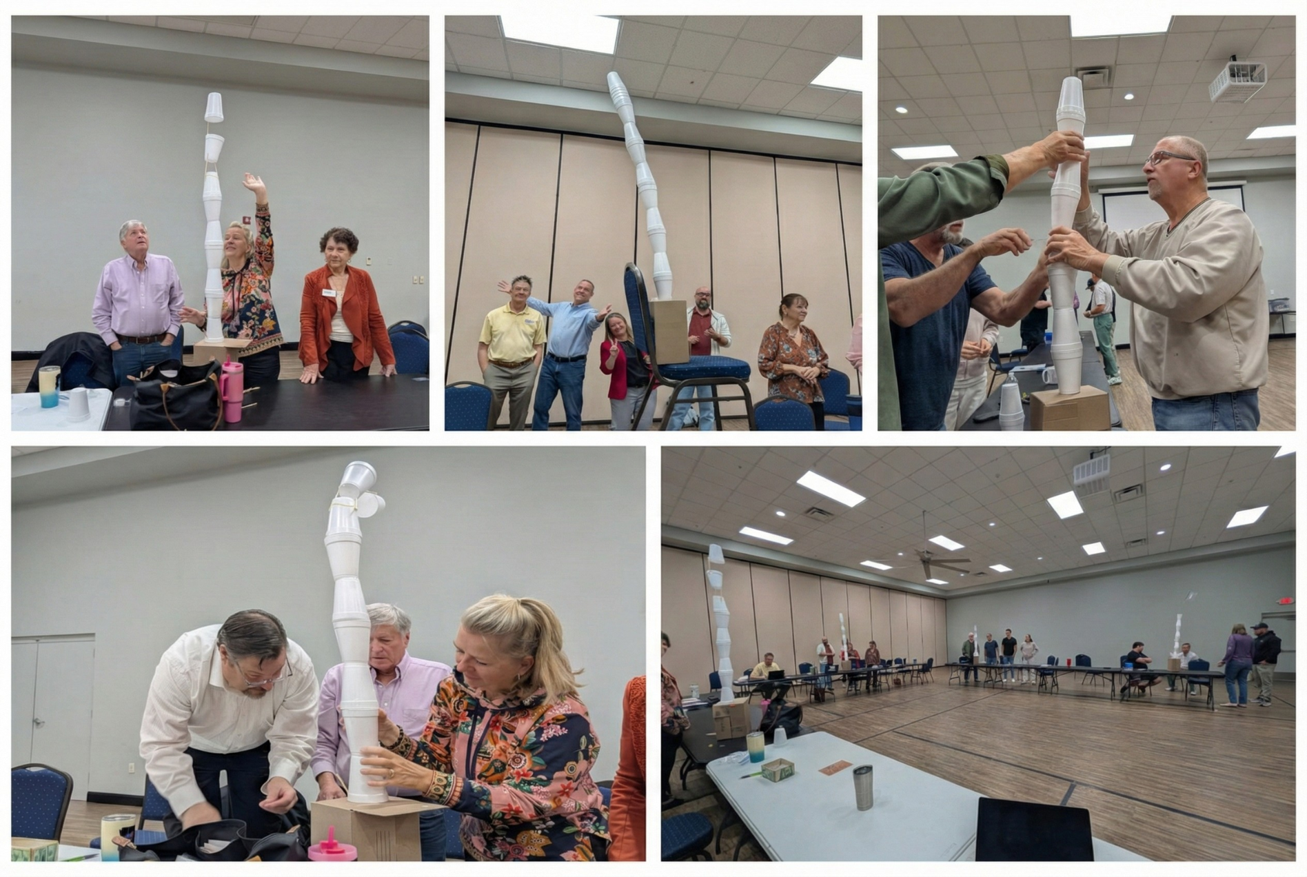 People building a tall structure out of white paper cups and cardboard, in a brightly lit room.