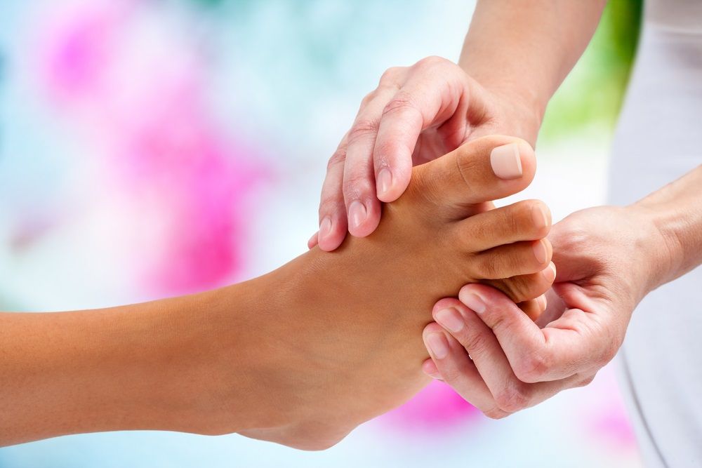 A Person Is Giving A Foot Massage To Another Person — Maitland Central Podiatry In Maitland NSW