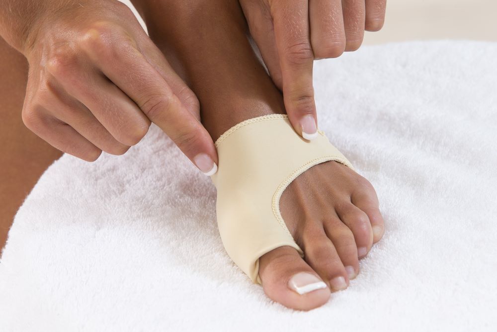 A Person is Putting a Bandage on Their Foot — Maitland Central Podiatry in Maitland