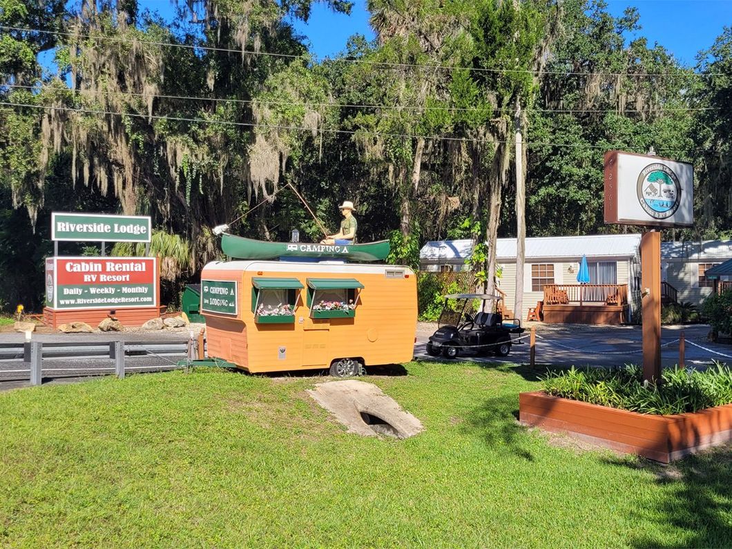 a sign for riverside lodge cabin rental rv resort