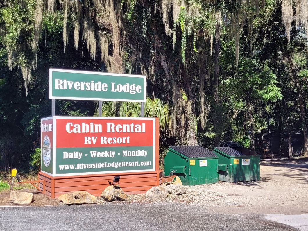 a sign for riverside lodge cabin rental rv resort