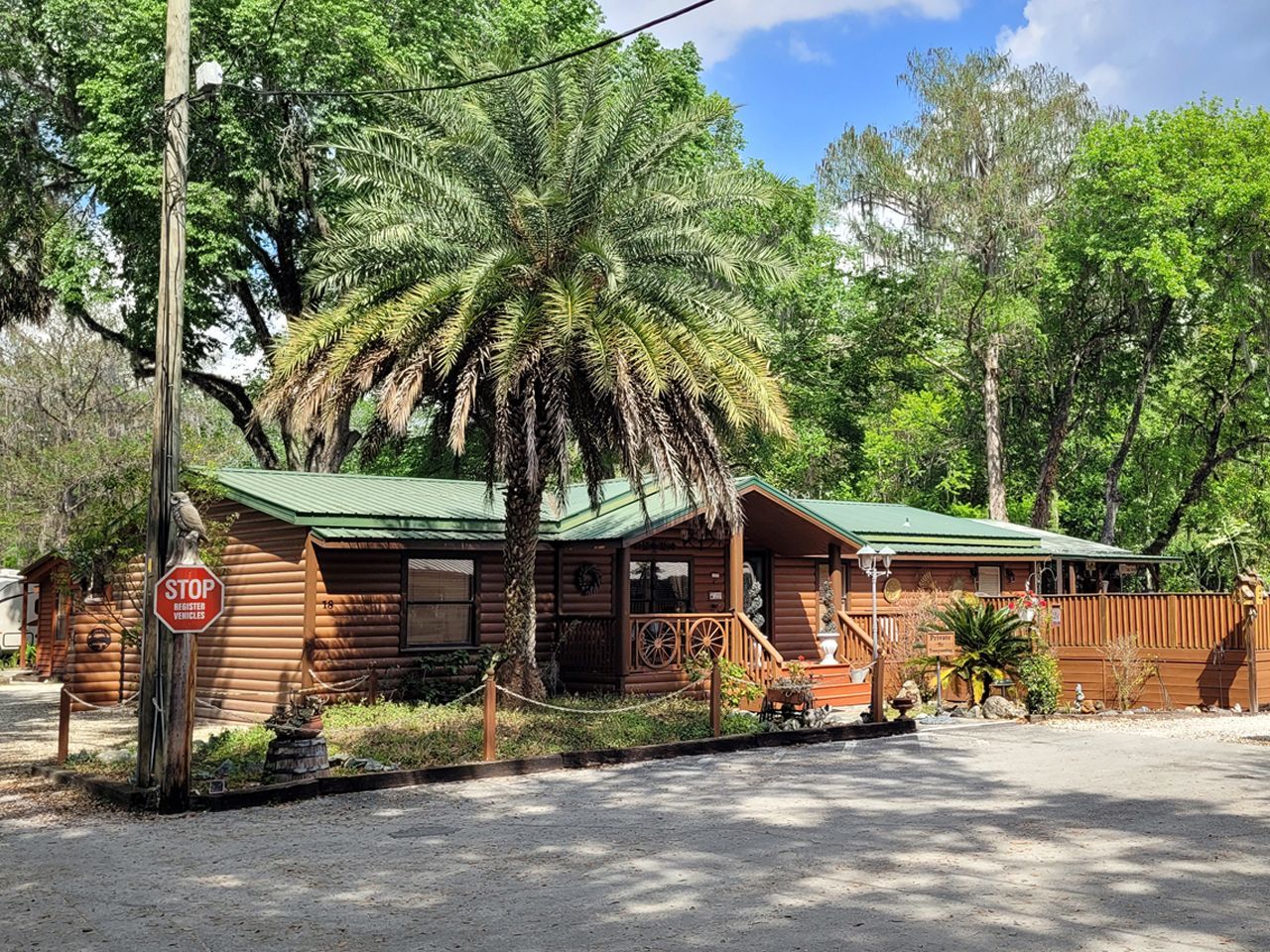 a stop sign is in front of a log cabin