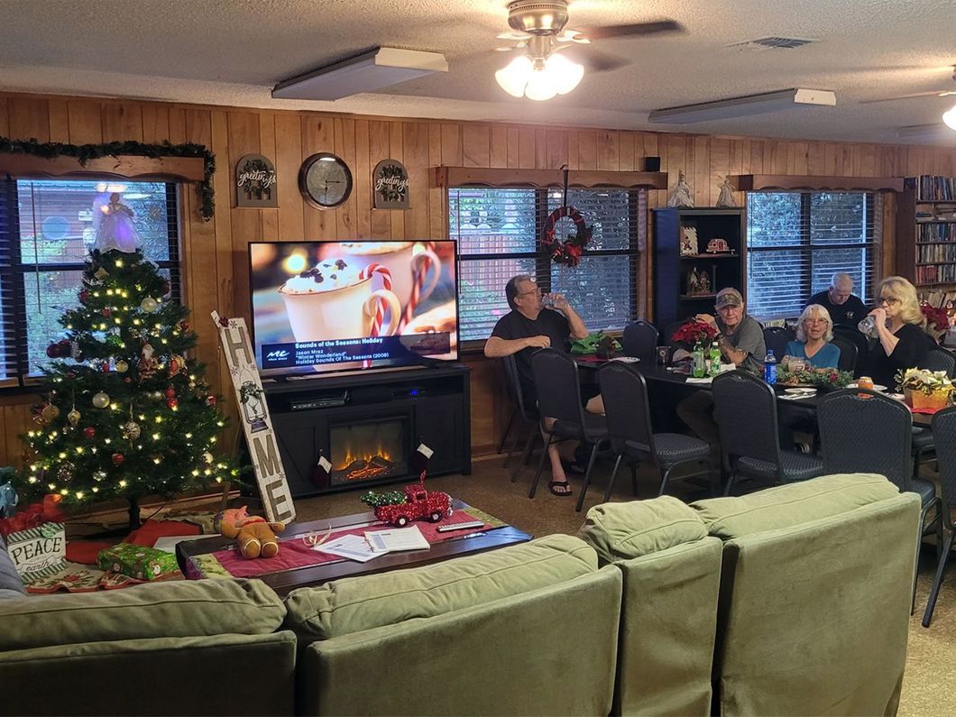a group of people are gathered in a living room watching a tv show about hot chocolate