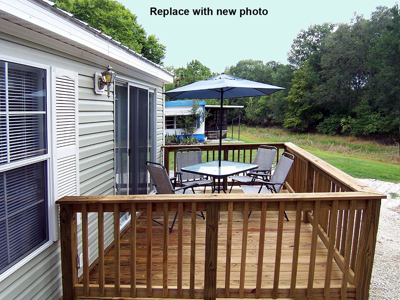 a wooden deck with a table and chairs in front of a mobile home