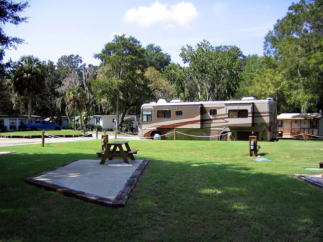 a rv parked in a grassy area with a picnic table