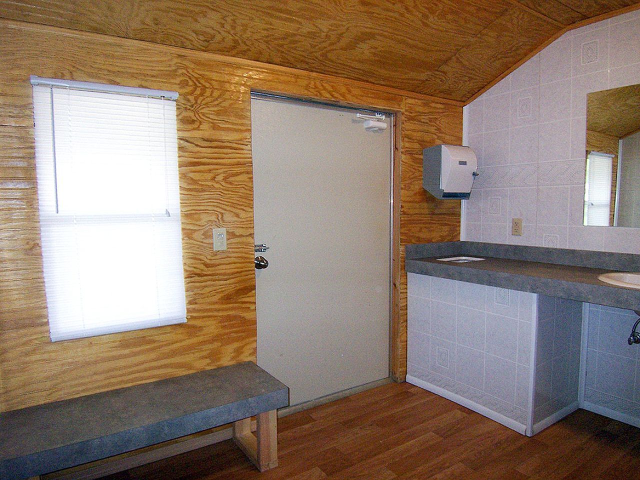 a bathroom with a sink a bench and a door