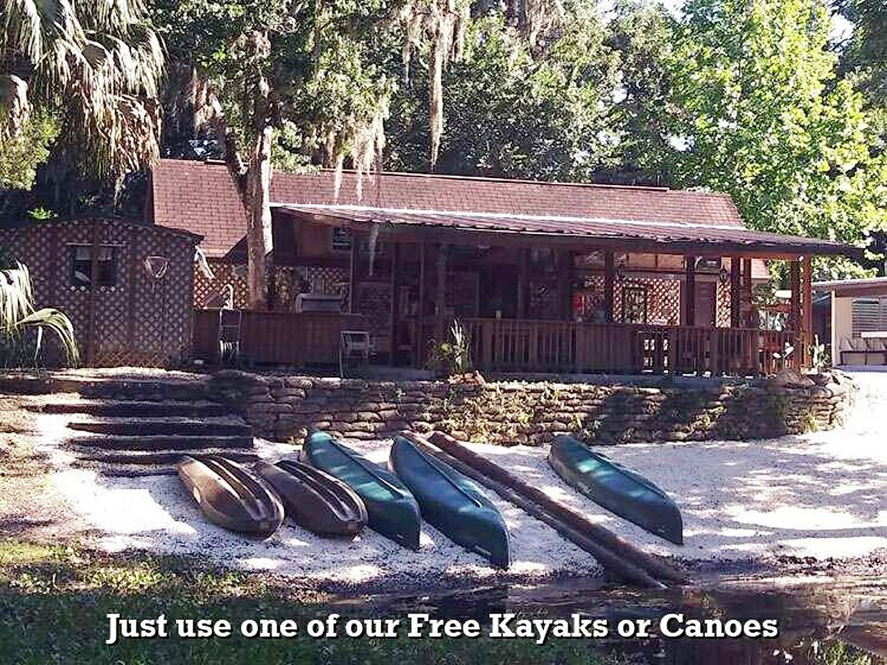 kayaks and canoes are lined up in front of a house