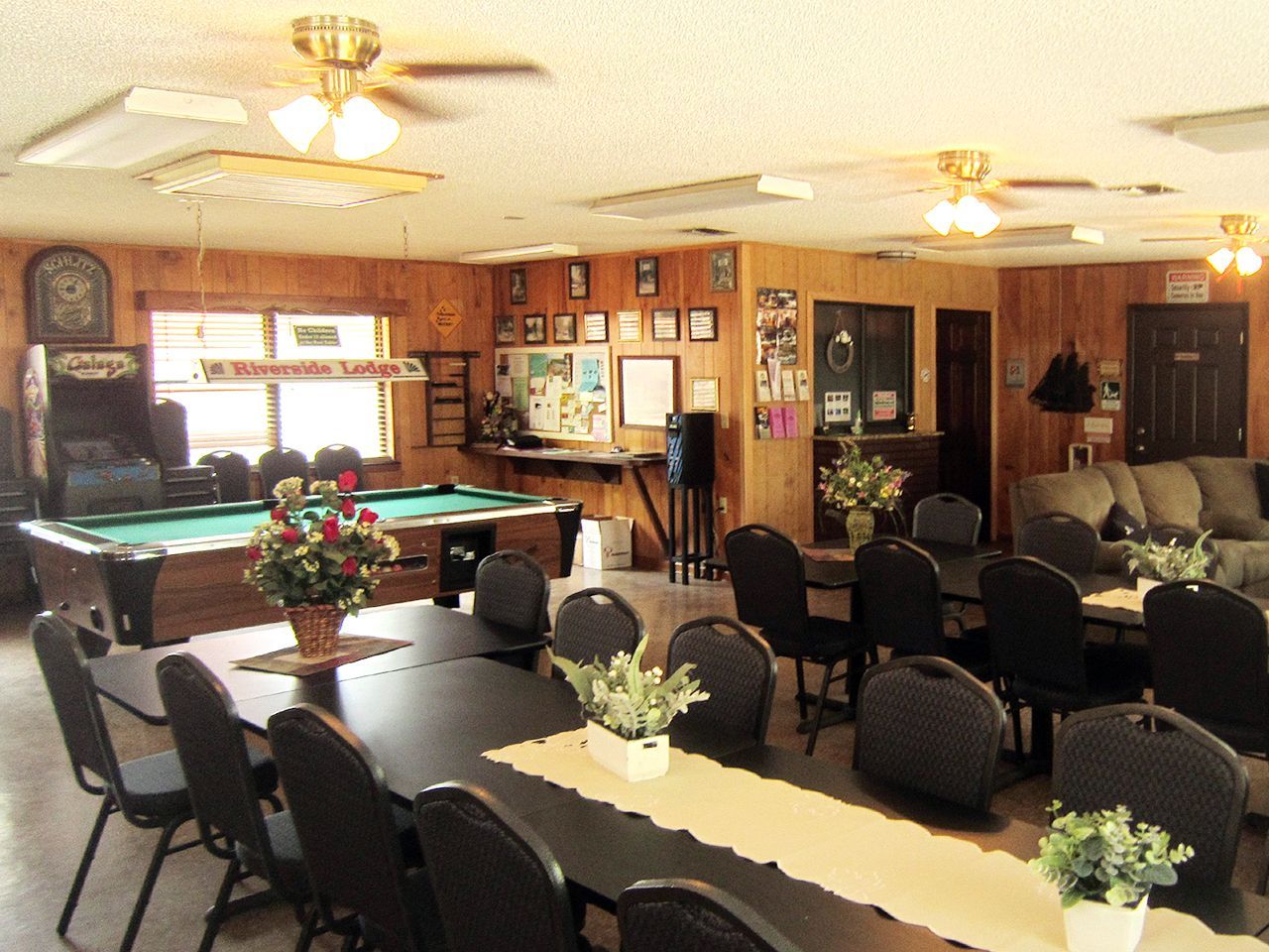 a large room with tables and chairs and a pool table