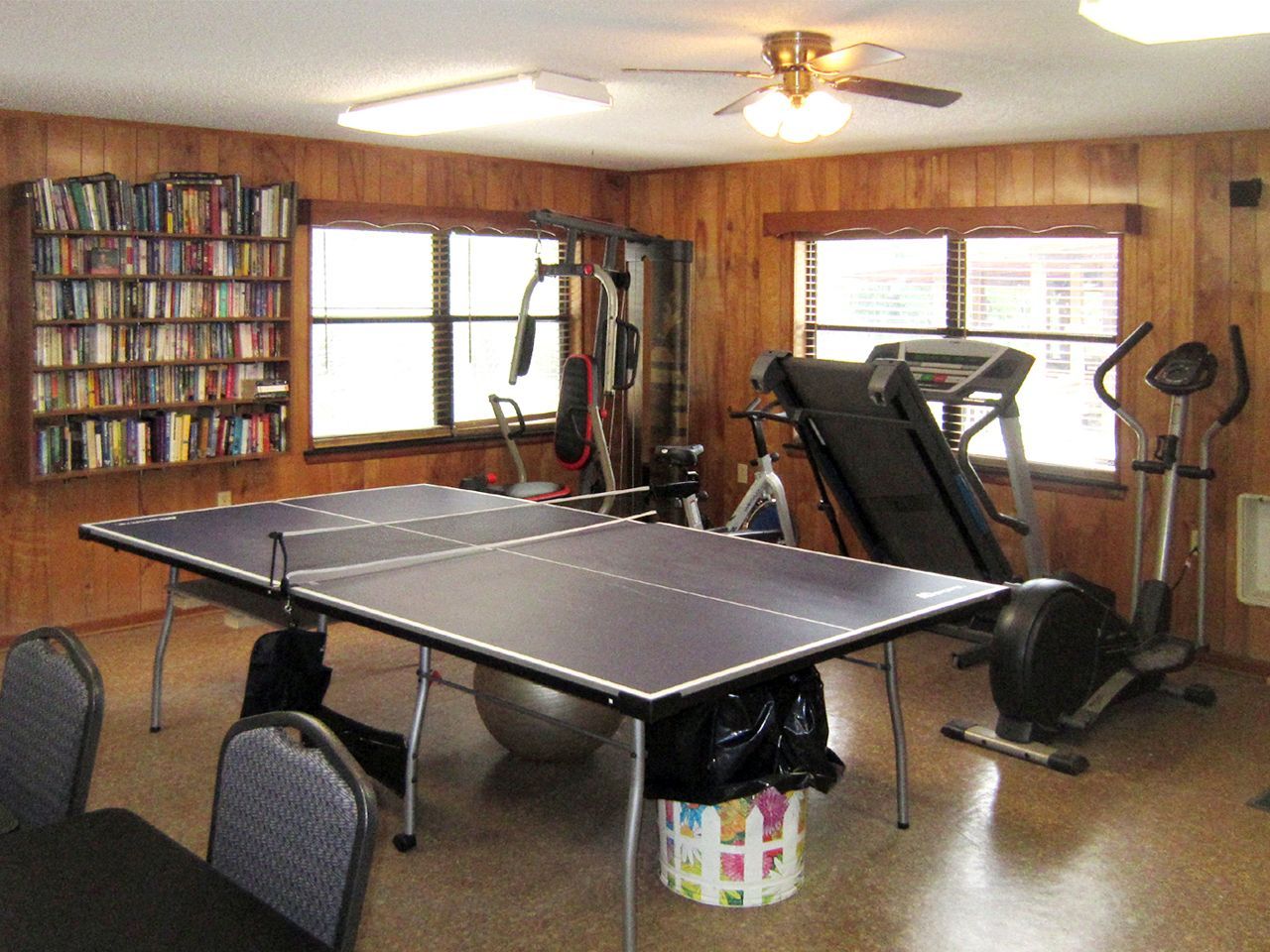 a room with a ping pong table and a treadmill