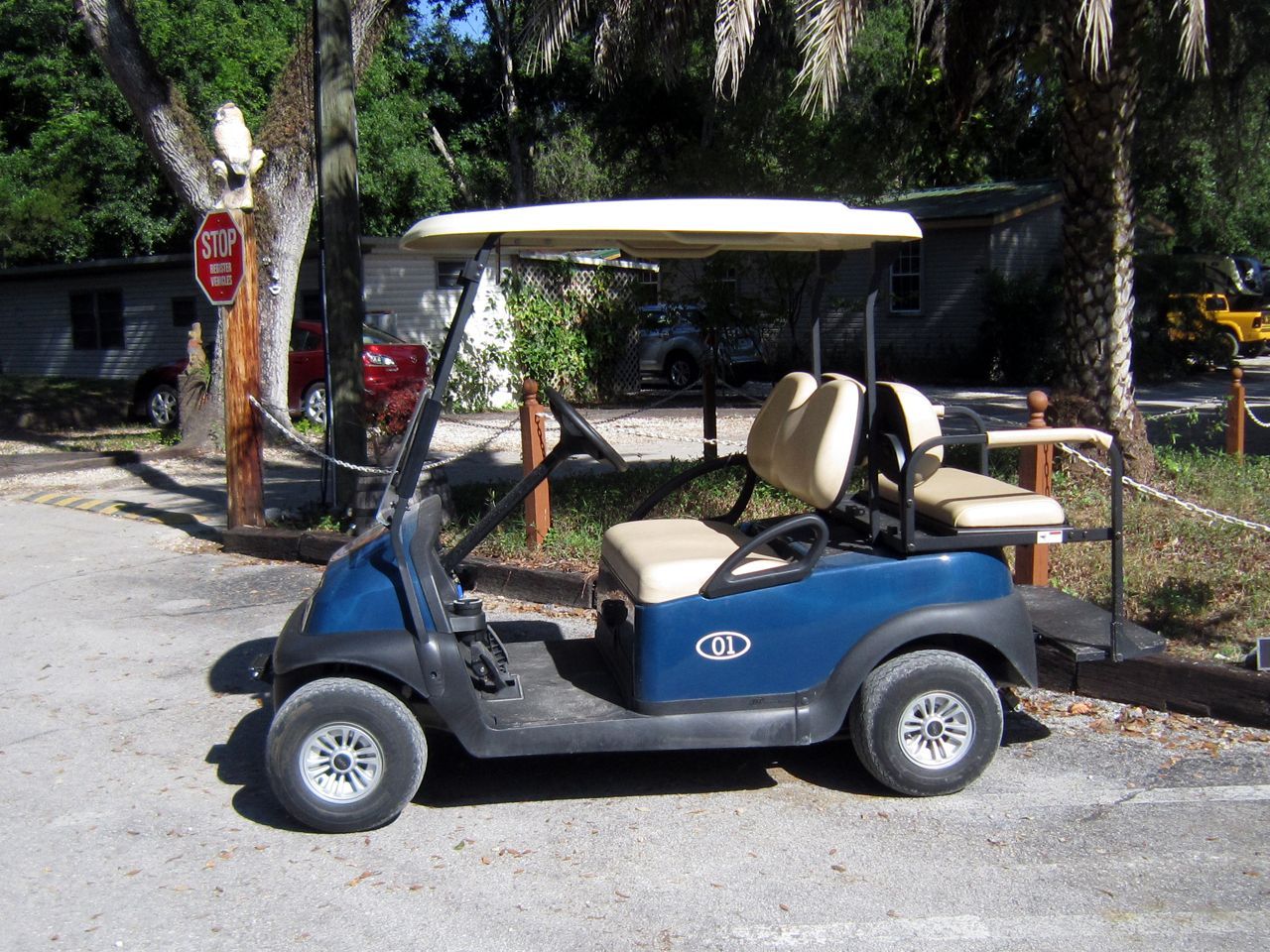 a blue golf cart is parked in front of a stop sign