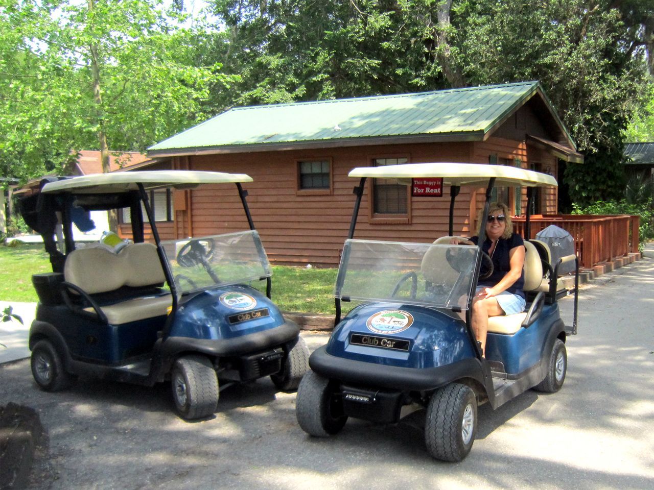 two golf carts are parked in front of a cabin