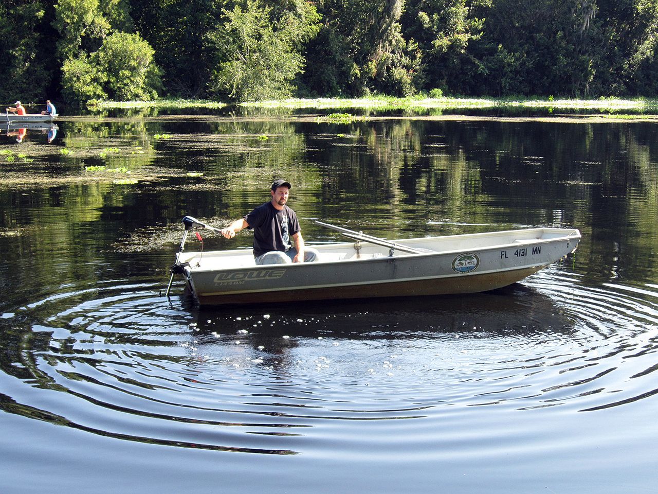 a man is sitting in a boat on a lake