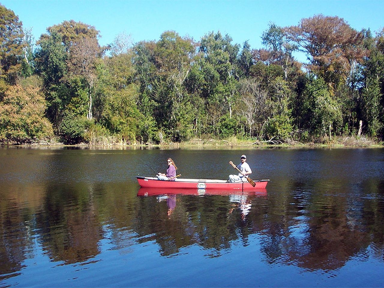 two people in a red canoe on a lake