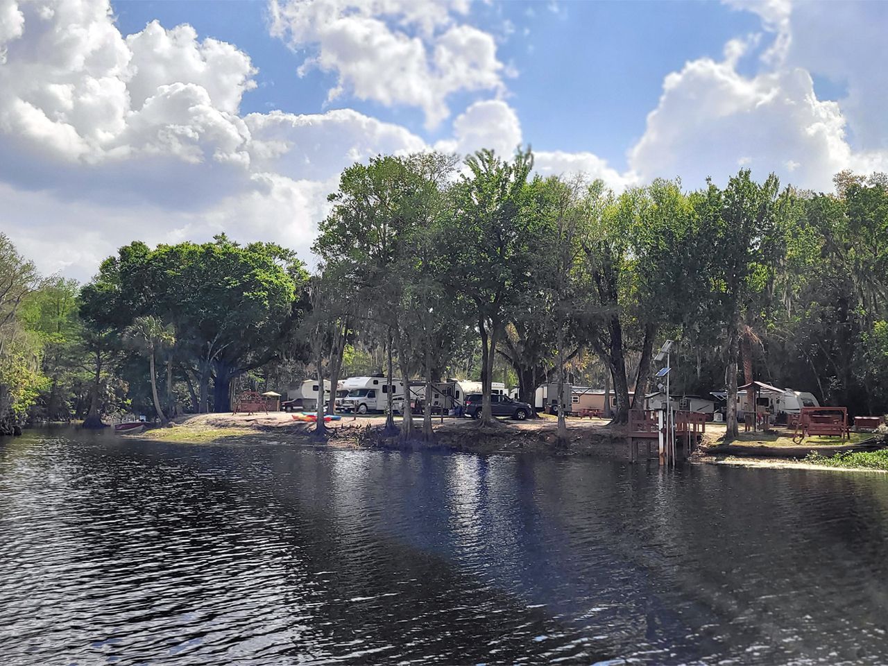 a large body of water surrounded by trees and a campground .