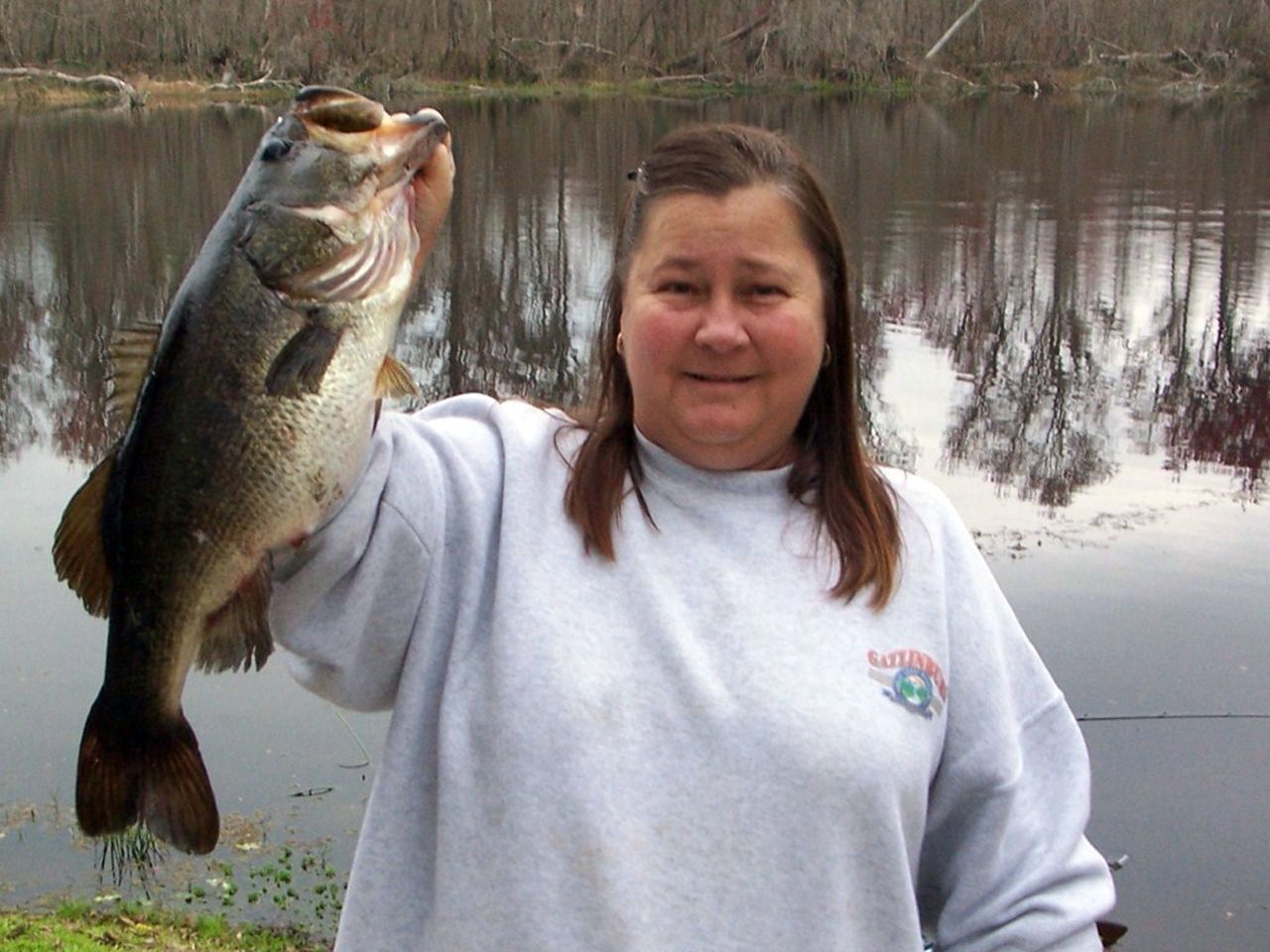 a woman is holding a large fish in her hand