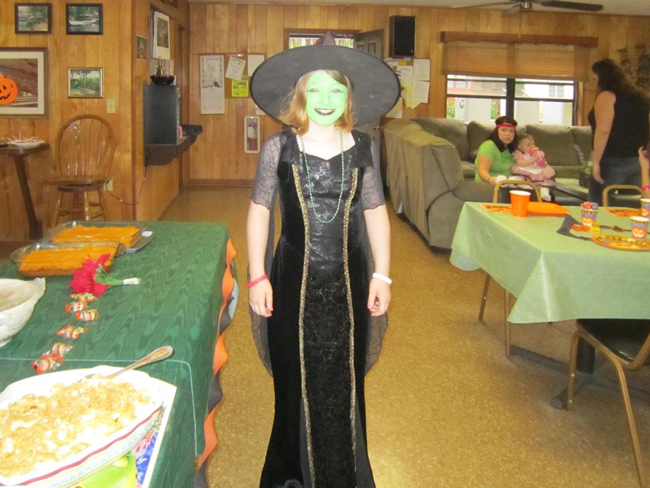 a girl dressed as a witch with green face paint