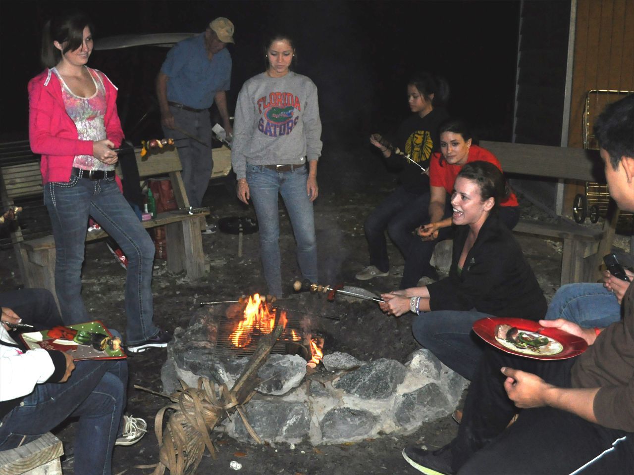 a group of people are gathered around a fire pit