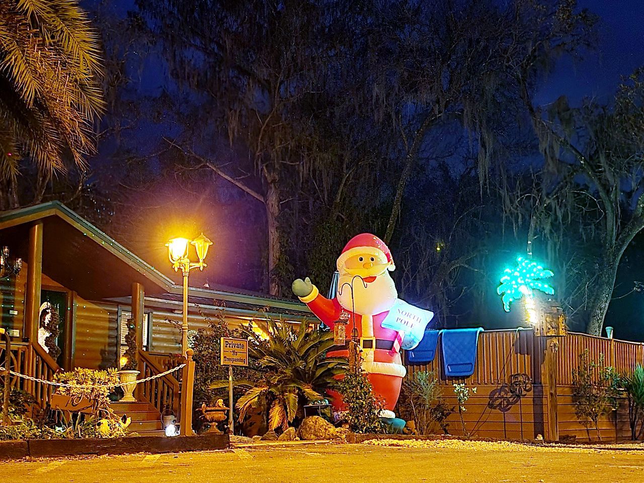 a large inflatable santa claus is in front of a house at night .