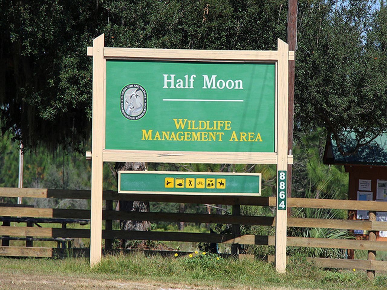 a green sign that says half moon wildlife management area
