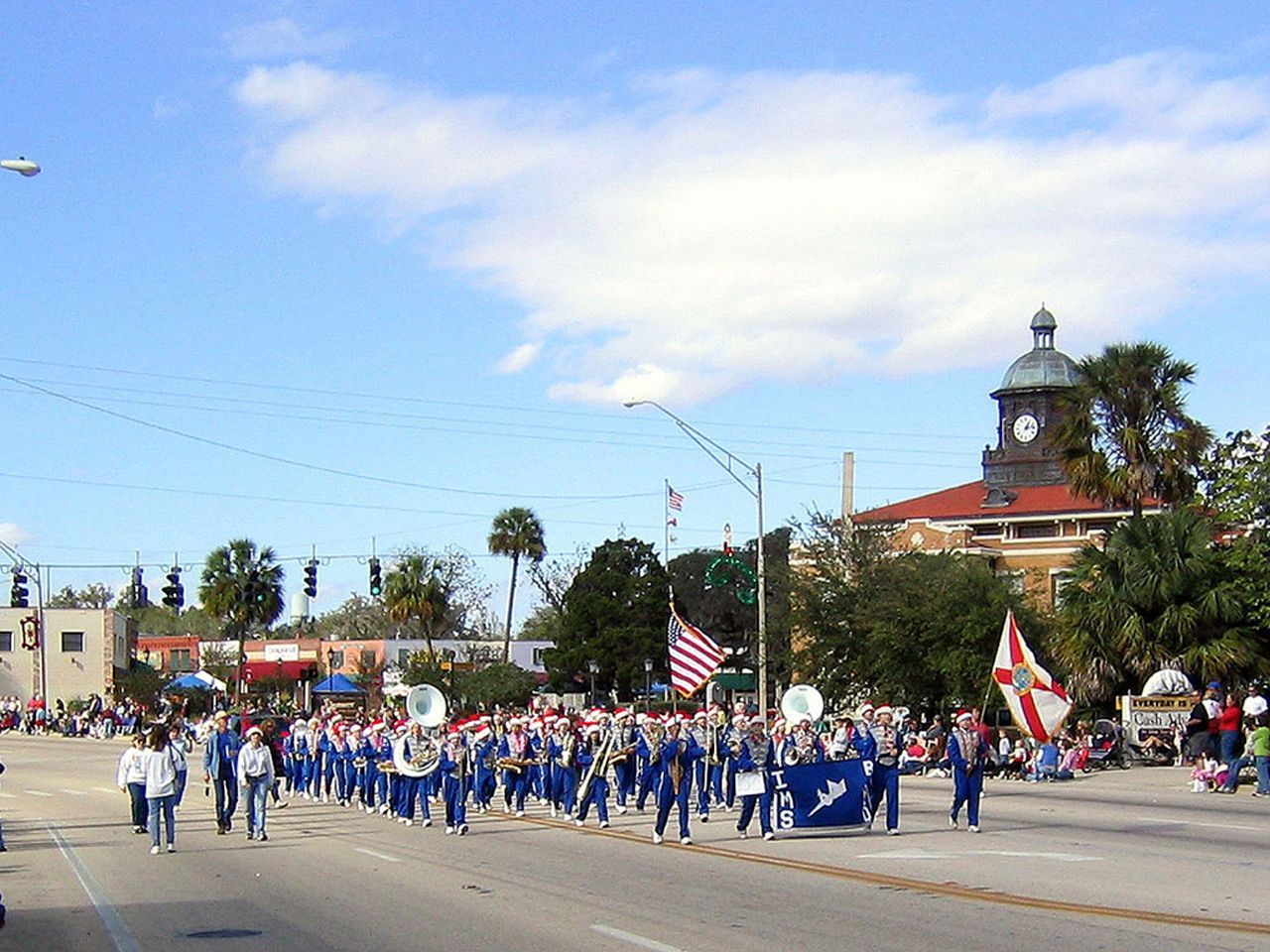 a parade with a clock tower in the background