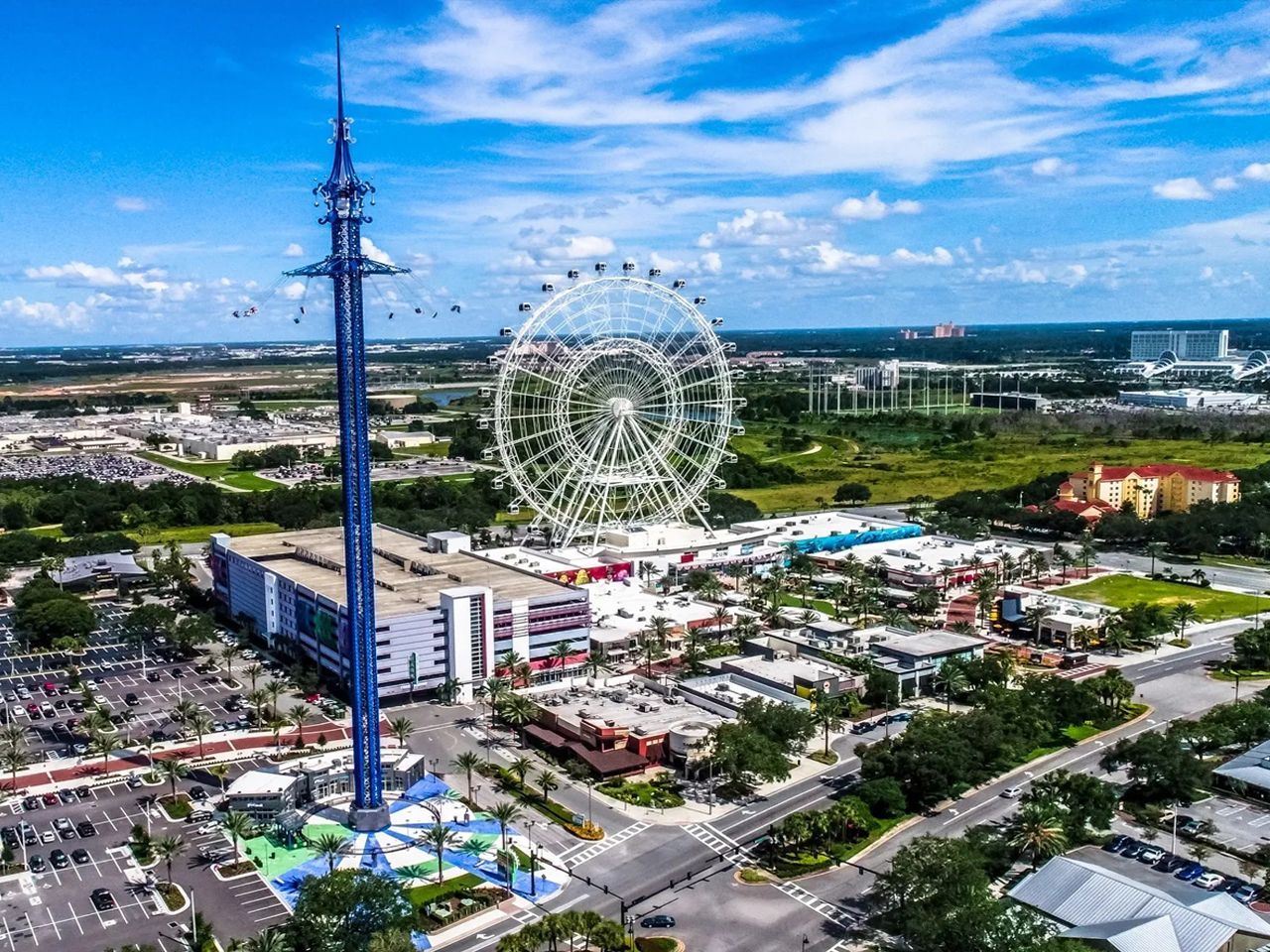 an aerial view of a theme park with a ferris wheel in the background .