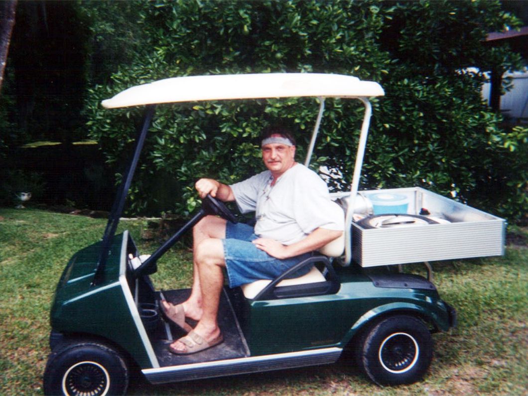 a man is sitting in a green golf cart