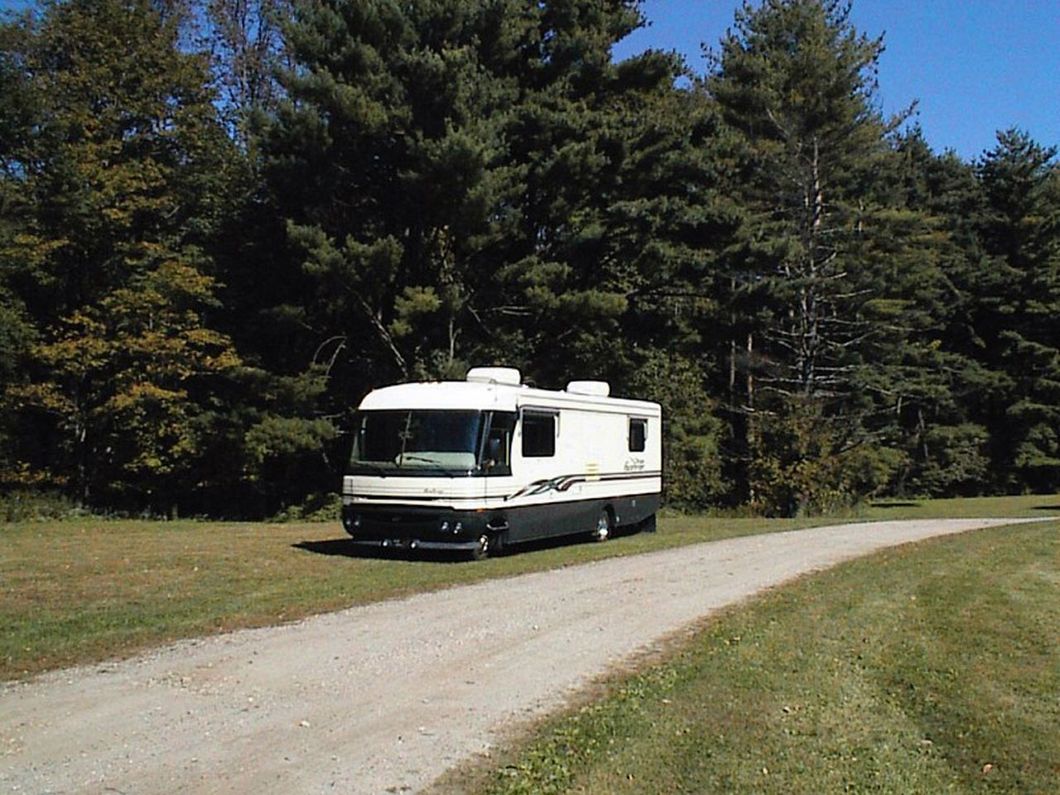 a rv is parked on the side of a dirt road