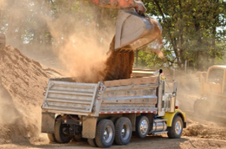 Excavator loading dirt in dump truck in Cheyenne WY