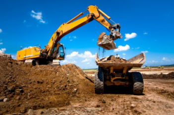 Excavator unloading dirt in loader for residential new construction in Cheyenne