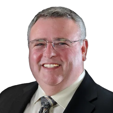 A man in a suit and tie is smiling for the camera