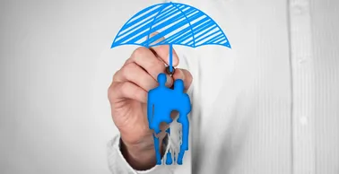 A man is holding a blue umbrella with a family cut out of it.