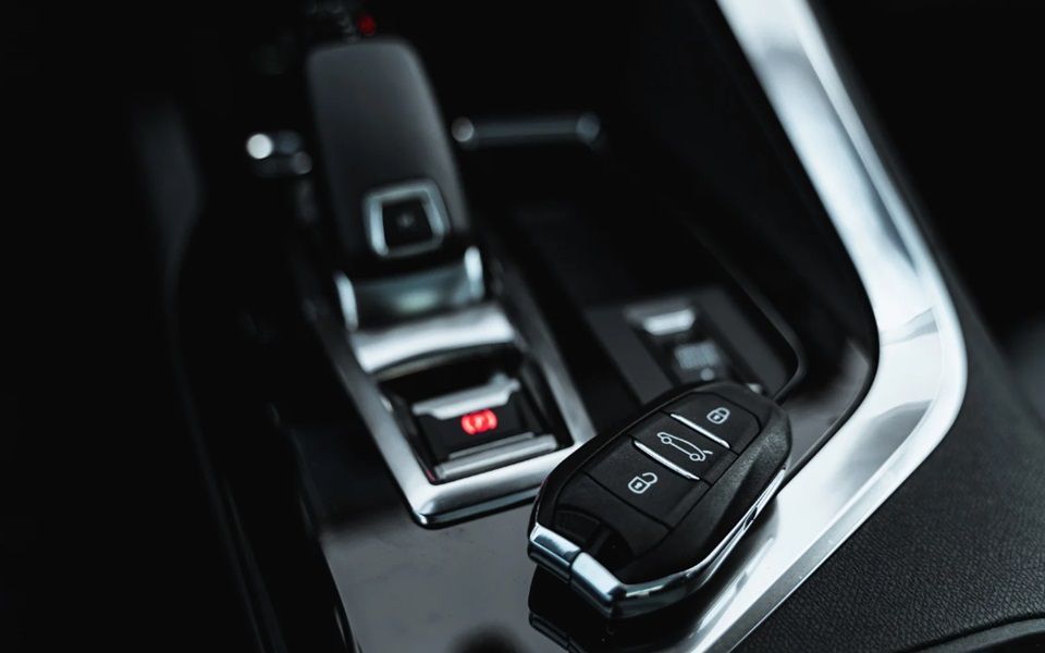 A car fob sitting on the center console of a vehicle.