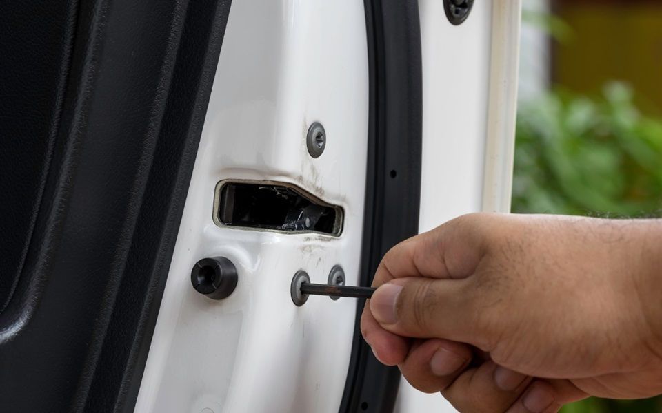 A car door lock is being repaired.