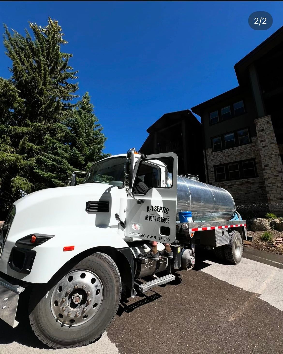 A large white truck is parked in front of a building.