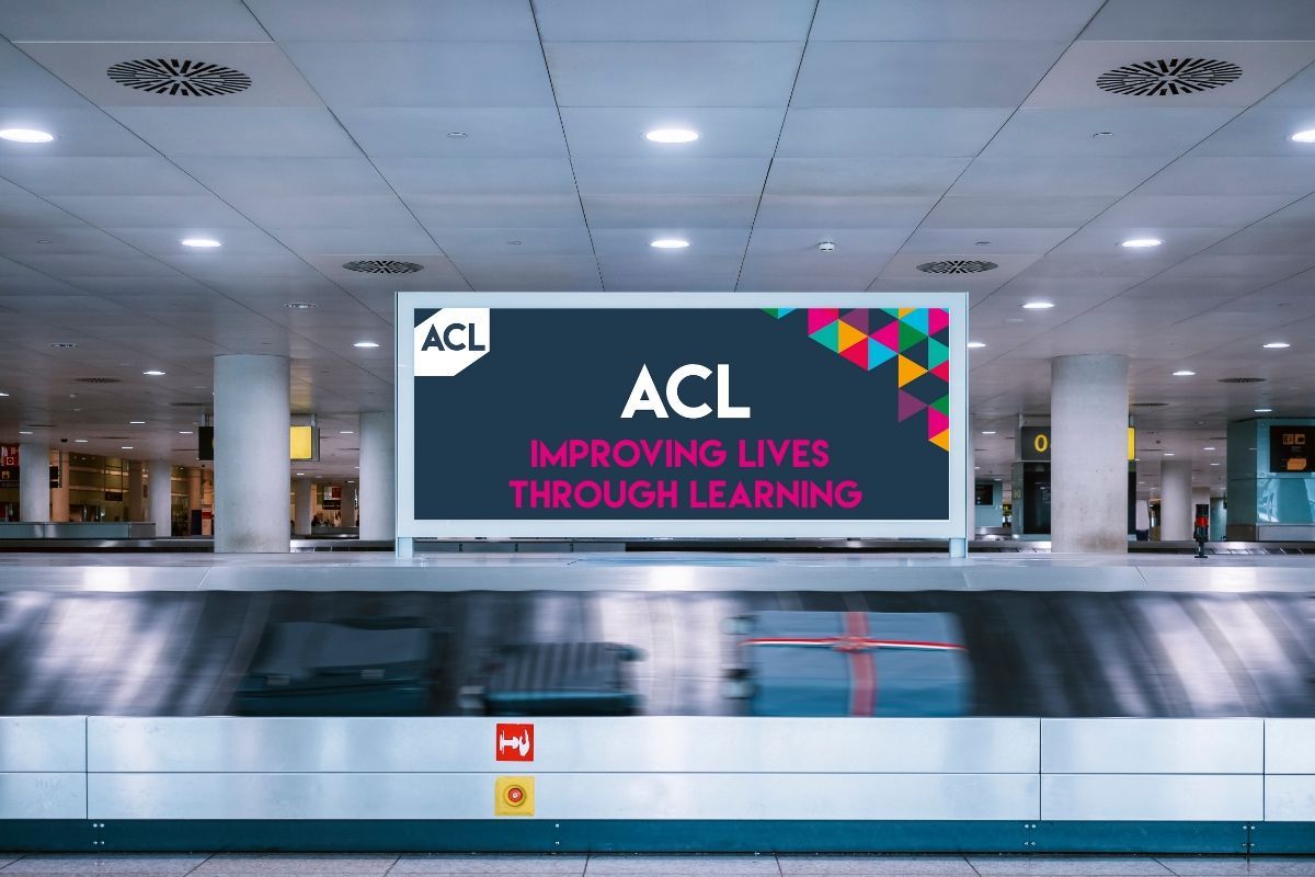 A billboard in an airport that says acl improving lives through learning