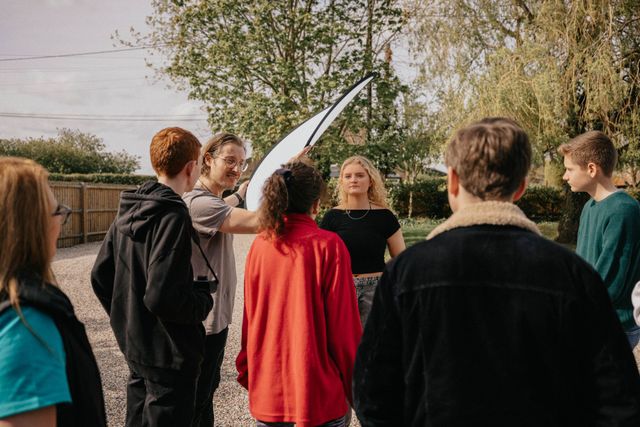 A group of young people are standing in a circle.