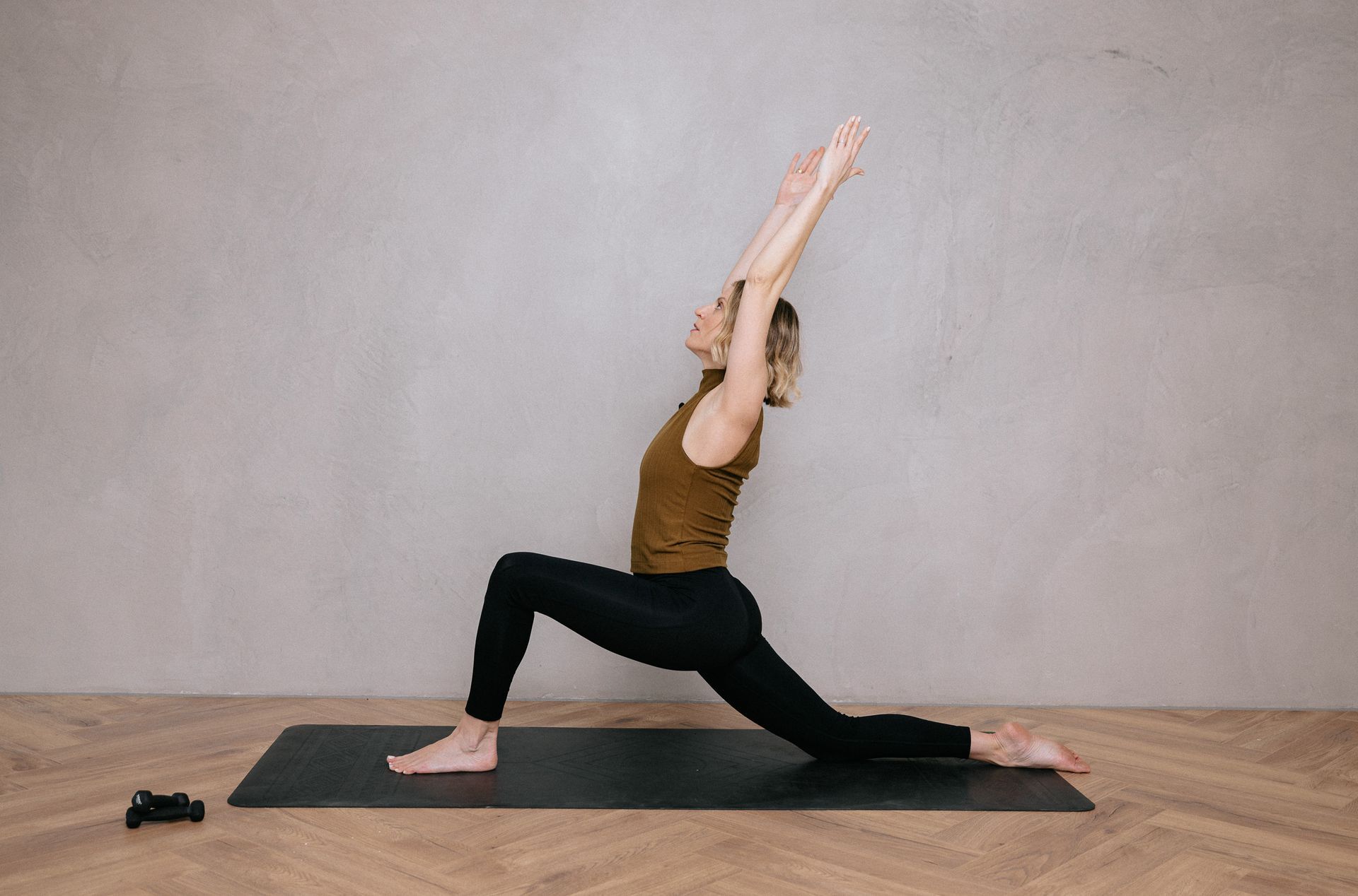 A woman is doing a yoga pose on a yoga mat.