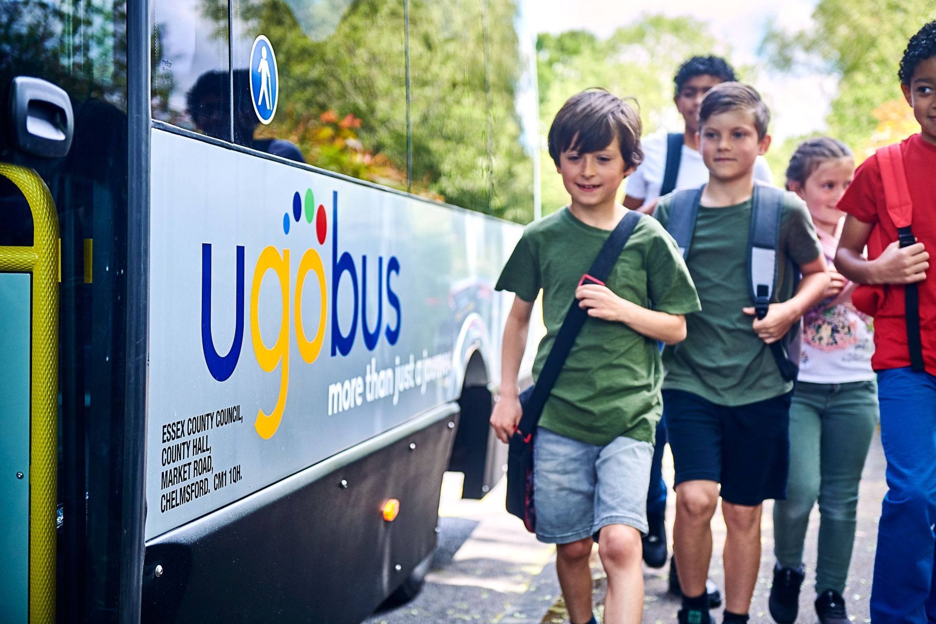 A group of children are walking towards a school bus.