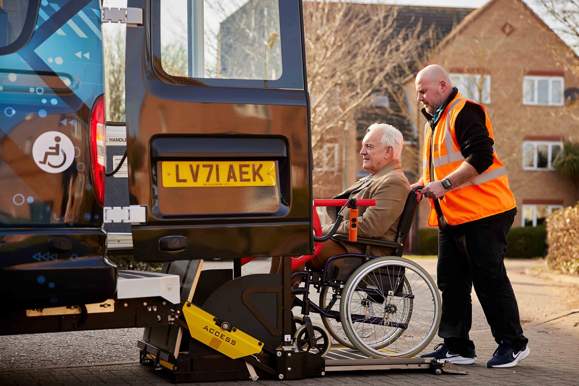 A man is pushing a man in a wheelchair into a van.