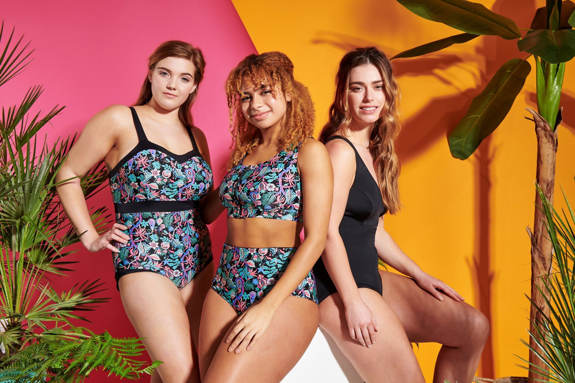 three women in swimsuits are posing for a picture .