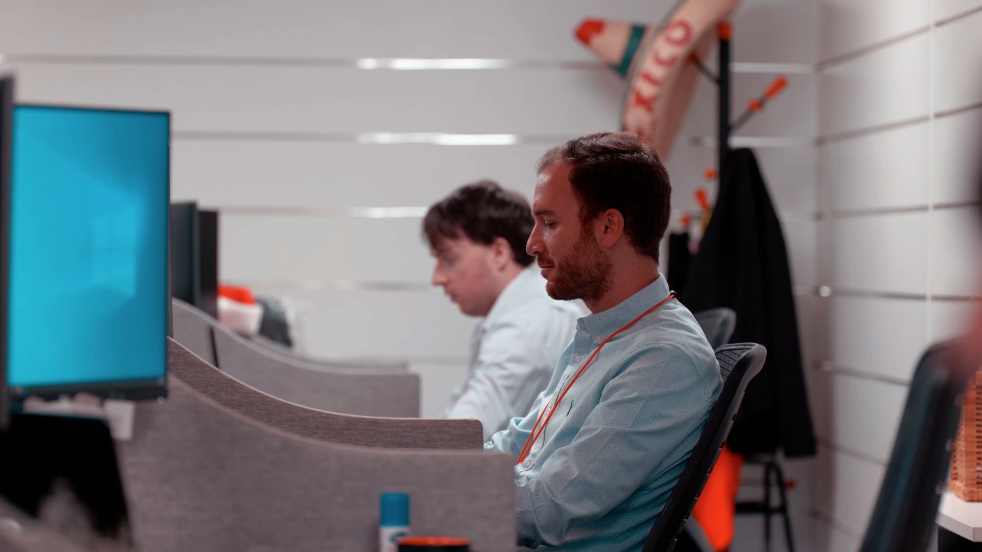 A man is sitting at a desk in front of a computer in an office.