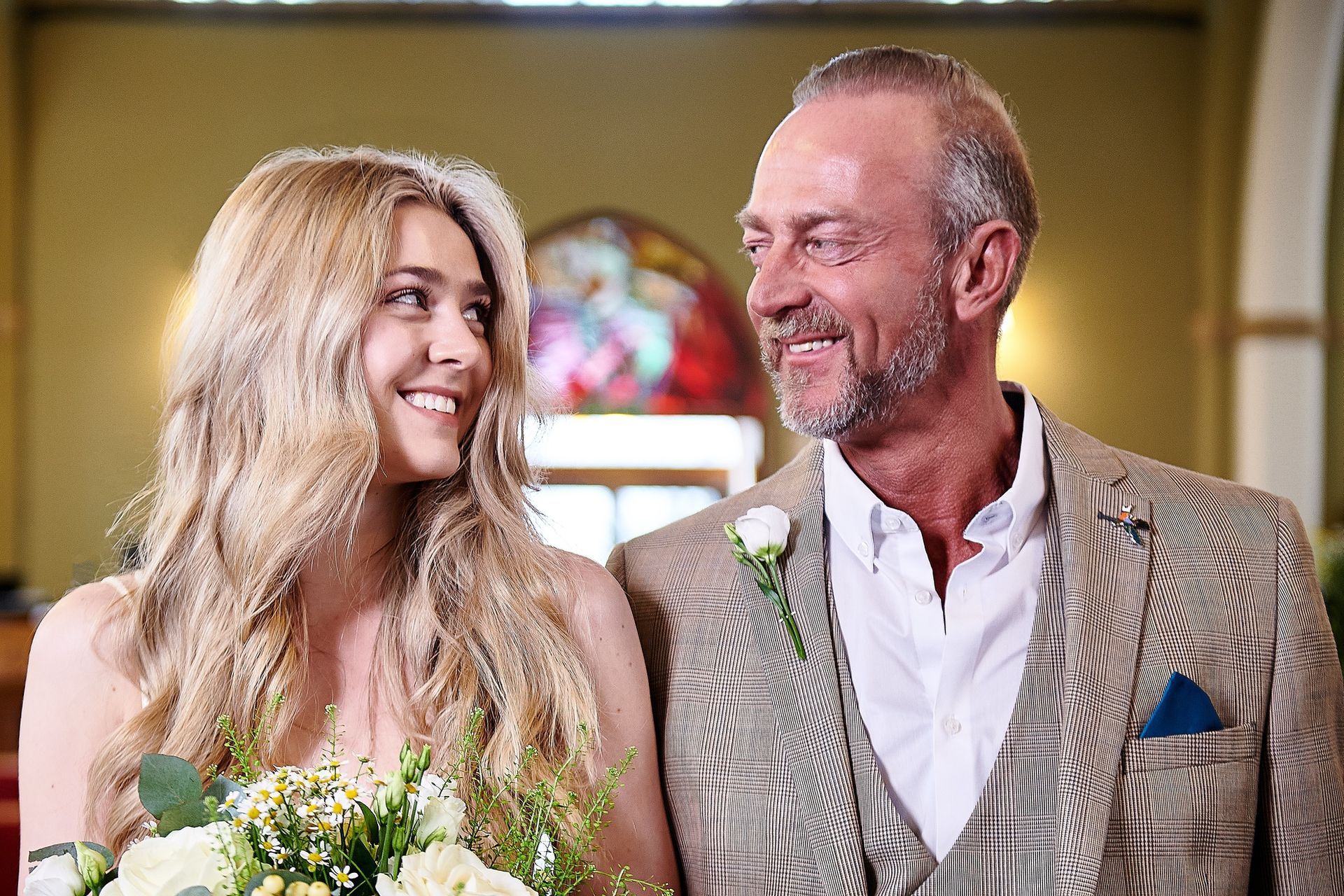 A man and a woman are standing next to each other in a church.