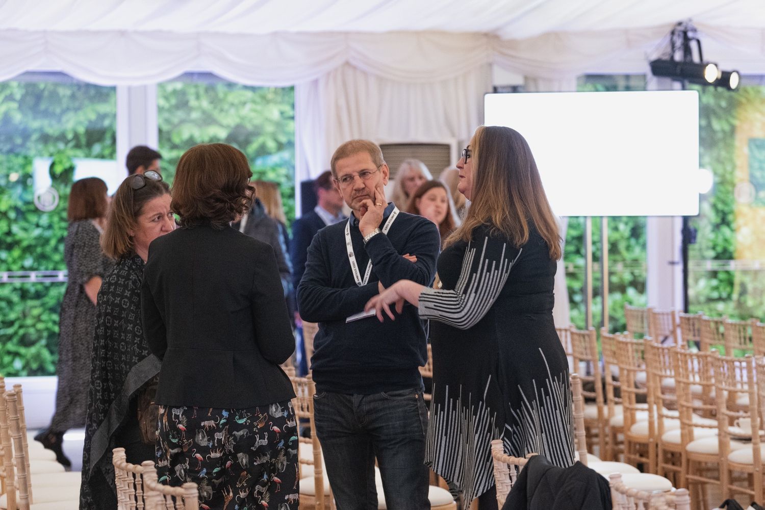 a group of people are standing in a tent talking to each other .