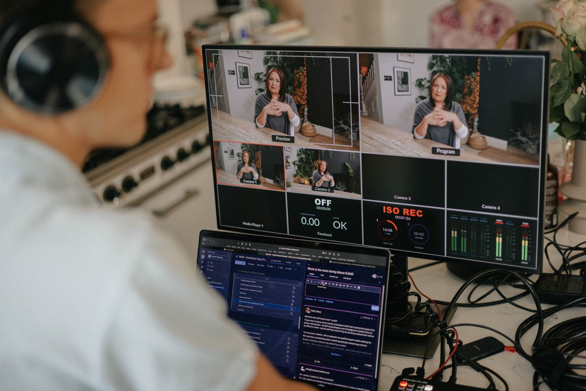 A man wearing headphones is sitting in front of a computer monitor.