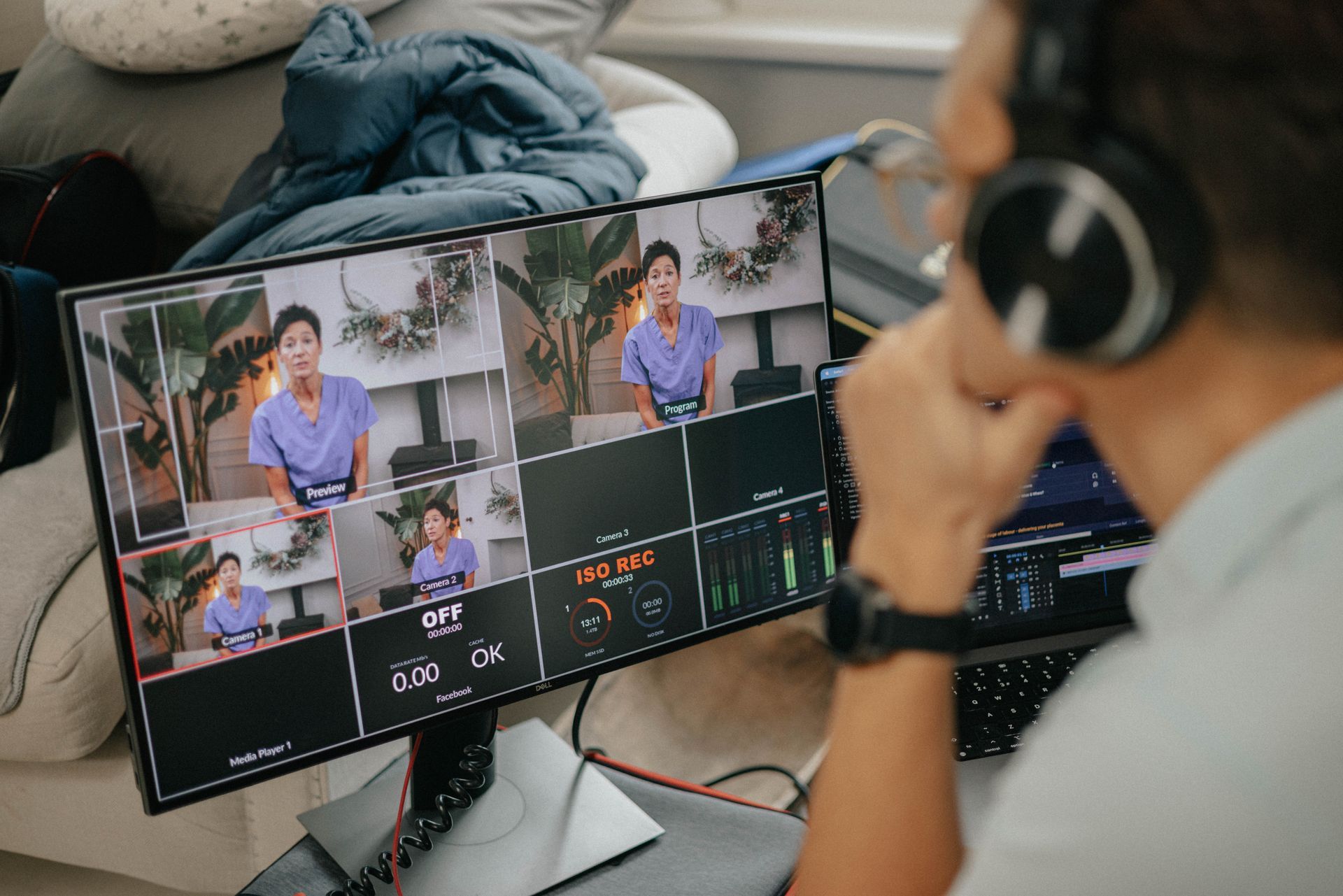 A man wearing headphones is sitting in front of a computer monitor.