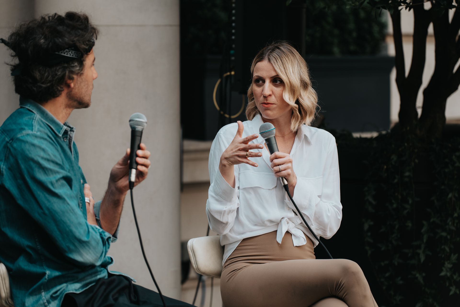 A man is holding a microphone and talking to a woman.
