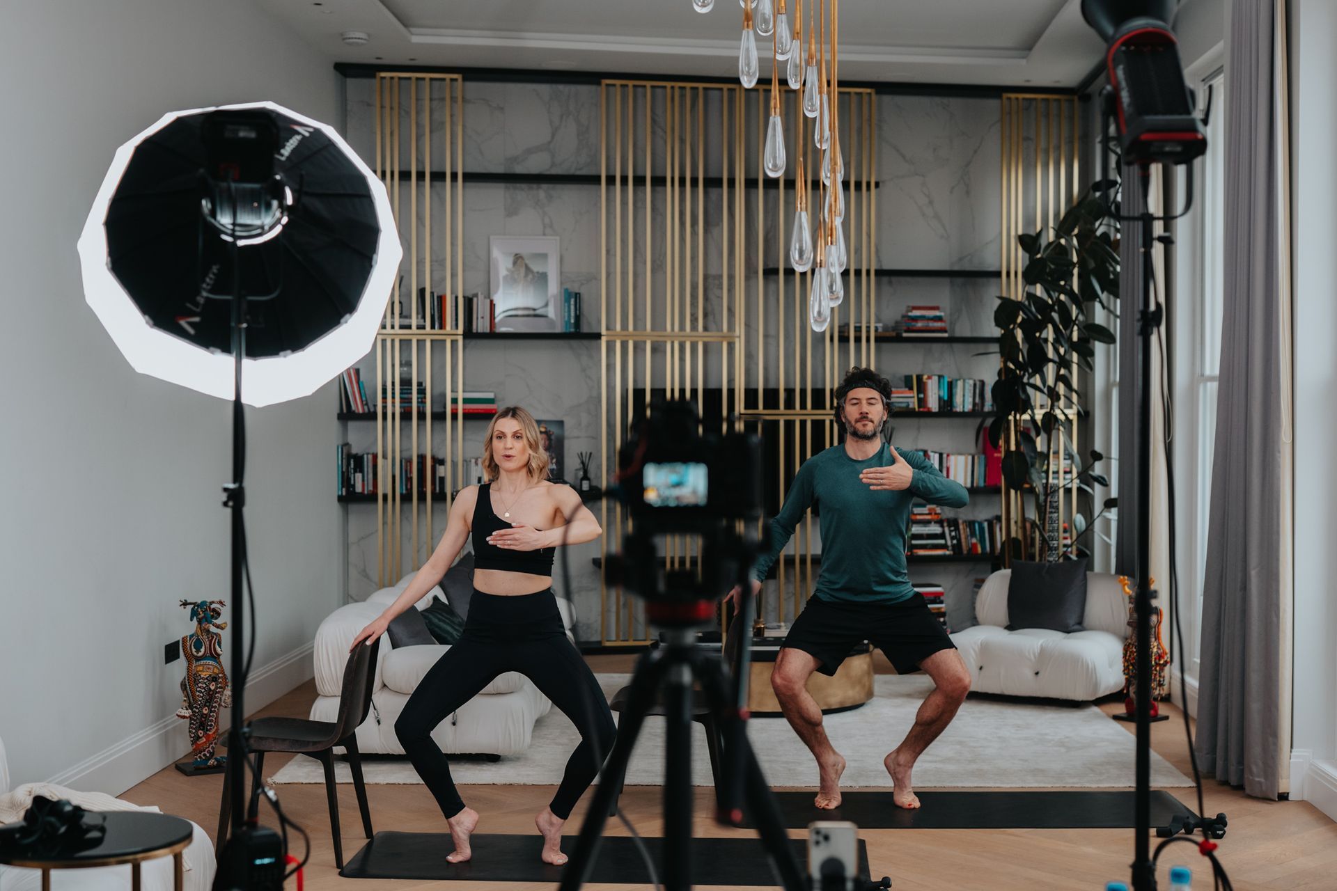 A man and a woman are doing yoga in a living room.