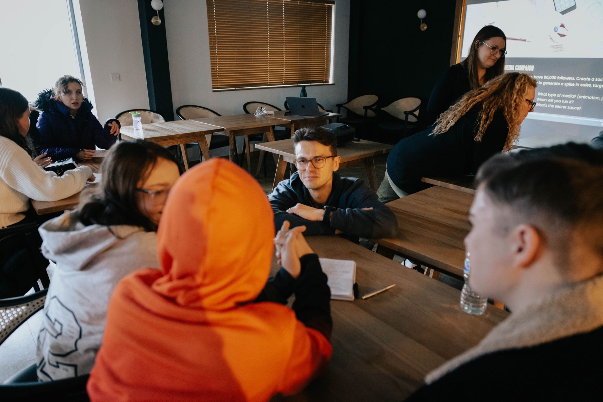 A group of people are sitting around a table in a room.